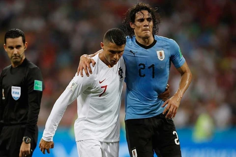 Cristiano Ronaldo giúp Edinson Cavani rời khỏi sân do chấn thương trong trận đấu thuộc vòng 1/8 World Cup 2018. (Nguồn: AP)