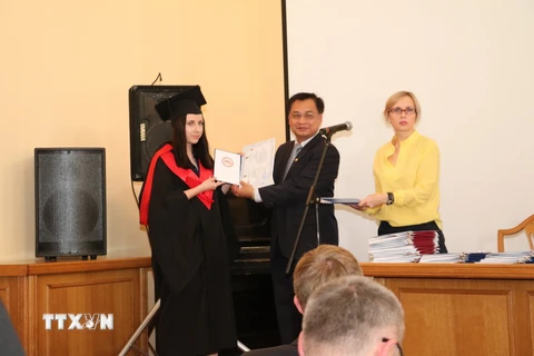 Đại sứ Nguyễn Anh Tuấn trao bằng cho tân thạc sỹ. (Ảnh: Dương Trí/TTXVN)