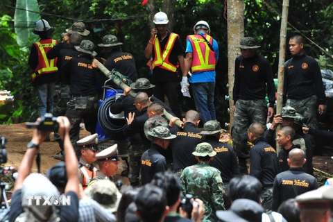 Lực lượng cứu hộ chuyển đường ống nước lớn vào hang động Tham Luang ở Chiang Rai ngày 6/7. (Nguồn: THX/TTXVN)