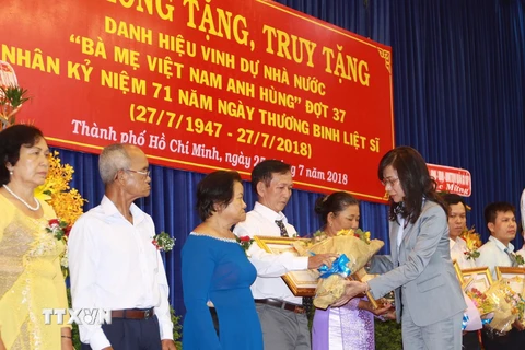 Bà Nguyễn Thị Thu, Phó Chủ tịch Ủy ban Nhân dân Thành phố Hồ Chí Minh trao bằng truy tặng danh hiệu Bà mẹ Việt Nam Anh hùng cho người thân của Mẹ. (Ảnh: Thanh Vũ/TTXVN)