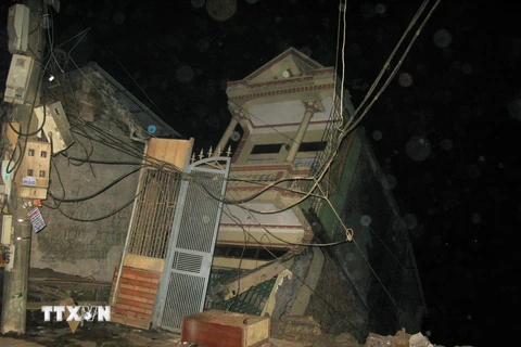 Một trong 8 ngôi nhà trong tình trạng bị đổ sập xuống dòng sông Đà. (Ảnh: Vũ Hà/TTXVN)