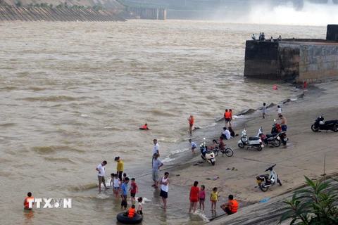 Người dân tắm sông khi Thủy điện Hòa Bình xả Lũ. (Ảnh: Thanh Hải/TTXVN)