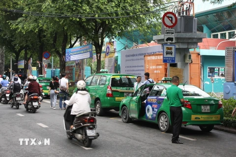 Xe taxi đón khách tại điểm đón trước cổng phụ Câu lạc bộ Văn hóa-Thể dục Thể thao Nguyễn Du. (Ảnh: Tiến Lực/TTXVN)