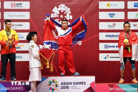 Vận động viên Việt Nam Thạch Kim Tuấn (trái) giành huy chương bạc, Om Yun Chol (giữa) của Triều Tiên giành huy chương vàng và Surahmat Bin Suwoto Wijoyo của Indonesia giành huy chương đồng nội dung cử tạ hạng 56kg. (Nguồn: AFP/ TTXVN
