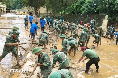 Lực lượng quân đội tỉnh Sơn La thu dọn bùn đất, khắc phục hậu quả mưa lũ tại trường Phổ thông dân tộc bán trú THCS xã Nà Ớt, huyện Mai Sơn (Sơn La). (Ảnh: Hồng Pha/TTXVN phát