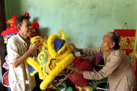 Vợ chồng nghệ nhân Nguyễn Tô (80 tuổi) và bà Trần Thị Tuyết (78 tuổi) với những sản phẩm lân truyền thống. (Ảnh: Phước Ngọc/TTXVN)