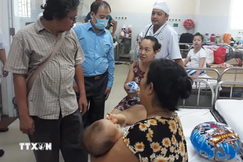 Đoàn làm việc của Cục Y tế dự phòng (Bộ Y tế) thăm hỏi các bệnh nhi tại Bệnh viện Nhi đồng Đồng Nai. (Ảnh: TTXVN/Vietnam+)