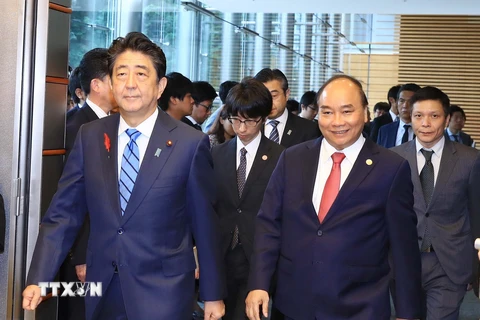 Thủ tướng Nguyễn Xuân Phúc và Thủ tướng Nhật Bản Shinzo Abe chuyển sang phòng họp báo sau khi kết thúc hội đàm. (Ảnh: Thống Nhất/TTXVN)