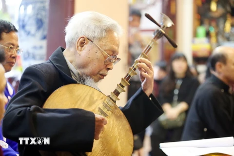 Lão nghệ nhân dân gian Hoàng Trọng Kha, 96 tuổi, đàn và hát văn tại Chương trình trải nghiệm: “Hát văn thi-Một thời vang bóng.” (Ảnh: Anh Tuấn/TTXVN)