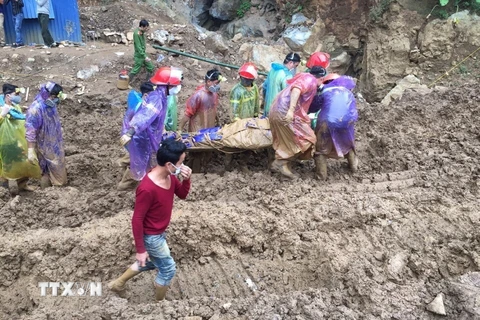 Các lực lượng cứu hộ chuyển thi thể nạn nhân trong vụ tai nạn sập hang khai thác vàng. (Ảnh: Vũ Thị Hà/TTXVN)