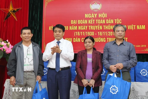 Chủ tịch Ủy ban Nhân dân thành phố Hà Nội Nguyễn Đức Chung tặng quà những gia đình nghèo ở khu dân cư số 3, phường Trung Liệt, quận Đống Đa. (Ảnh: Lâm Khánh/TTXVN)