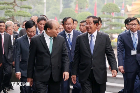 Thủ tướng Nguyễn Xuân Phúc trao đổi thân mật với Thủ tướng Campuchia Samdech Techo Hun Sen trên đường đến Trụ sở Chính phủ để hội đàm. (Ảnh: Văn Điệp/TTXVN)