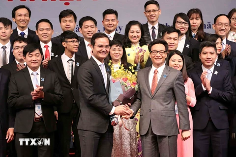 Phó Thủ tướng Vũ Đức Đam tặng hoa chúc mừng đồng chí Bùi Quang Huy và Ban Chấp hành Trung ương Hội Sinh viên Việt Nam lần thứ X. (Ảnh: Văn Điệp/TTXVN)