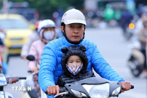 Các em nhỏ mặc áo ấm khi ra đường (ảnh chụp trên đường Tân Mai, Hà Nội). (Ảnh: Danh Lam/TTXVN)