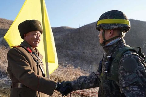 Lính biên phòng hai nước Hàn Quốc, Triều Tiên bắt tay nhau. (Nguồn: Bộ Quốc phòng Hàn Quốc/koreatimes.co.kr)