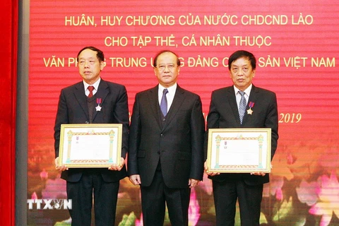 Ông Bosengkham Vongdara, Bộ trưởng Bộ Thông tin, Văn hoá và Du lịch Lào trao tặng Huân chương Lao động hạng Nhất và hạng Nhì của Chủ tịch nước Lào cho hai cá nhân của Văn phòng Trung ương Đảng. (Ảnh: Nguyễn Dân/TTXVN)