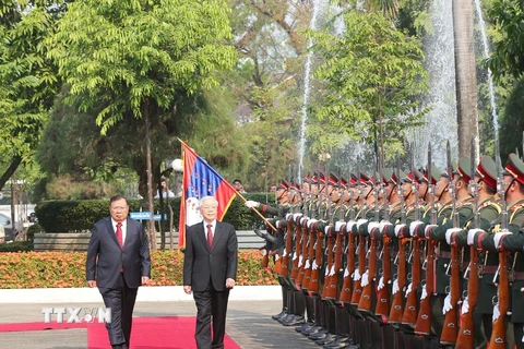 Tổng Bí thư, Chủ tịch nước Lào Bounnhang Vorachith và Tổng Bí thư, Chủ tịch nước Nguyễn Phú Trọng duyệt đội danh dự Quân đội nhân dân Lào tại Lễ đón chính thức. (Ảnh: Trí Dũng/TTXVN)