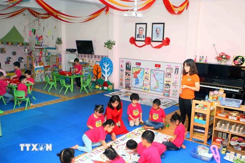 Cô giáo và các trẻ tại lớp học mang tên Kim Nhật Thành tham gia vẽ bức tranh về chủ đề Tình hữu nghị giữa hai nước Việt Nam-Triều Tiên. (Ảnh: Thanh Tùng/TTXVN)