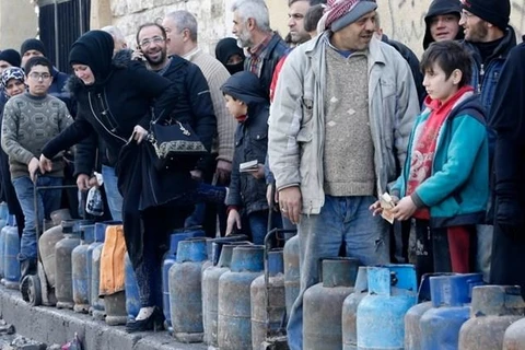 Người dân Syria xếp hàng chờ đổi khí đốt ở quận Salah al-Din của thành phố phía bắc Aleppo, ngày 11/2. (Nguồn: AFP)