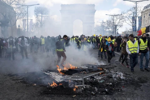 Người biểu tình Áo vàng đốt các rào chắn trên đại lộ Champs-Elysees ở Paris, Pháp, ngày 16/3. (Nguồn: THX/TTXVN)