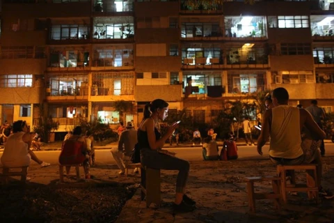 Người dân Cuba sử dụng điện thoại di động để kết nối Internet tại một điểm phát mạng không dây ở trung tâm La Habana, Cuba. (Nguồn: REUTERS)