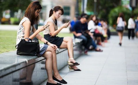 Người dân lướt mạng qua điện thoại di động thông minh ở Singapore. (Nguồn: Bloomberg)