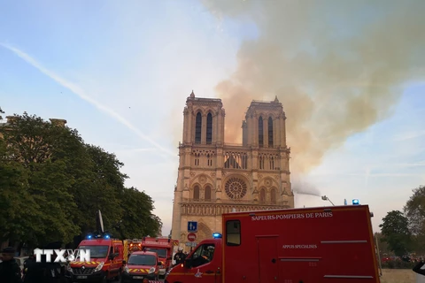 Lính cứu hỏa nỗ lực dập lửa tại hiện trường vụ hỏa hoạn Nhà thờ Đức Bà ở Paris (Pháp) ngày 15/4/2019. (Nguồn: THX/TTXVN)