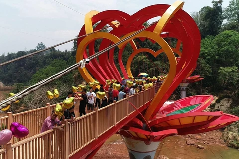 Du khách tham quan và trải nghiệm cầu kính tình yêu tại Khu du lịch sinh thái thác Dải Yếm, huyện Mộc Châu, tỉnh Sơn La. (Nguồn: TTXVN phát)