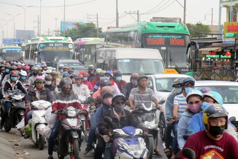 Người dân trở lại Thành phố Hồ Chí Minh trên tuyến quốc lộ 1A (huyện Bình Chánh). (Ảnh: Hoàng Hải/TTXVN)
