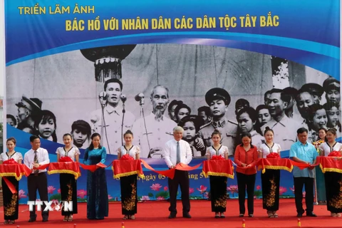 Các vị lãnh đạo tỉnh Sơn La và lãnh đạo Ban Quản lý Di tích Chủ tịch Hồ Chí Minh cắt băng khai mạc triển lãm ảnh 'Bác Hồ với nhân dân các dân tộc Tây Bắc.' (Ảnh: Nguyễn Cường/TTXVN)