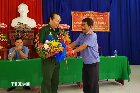 Đại diện Viện Kiểm sát Nhân dân tỉnh Tây Ninh tặng hoa xin lỗi ông Nguyễn Văn Dũng. (Ảnh: Lê Đức Hoảnh/TTXVN)