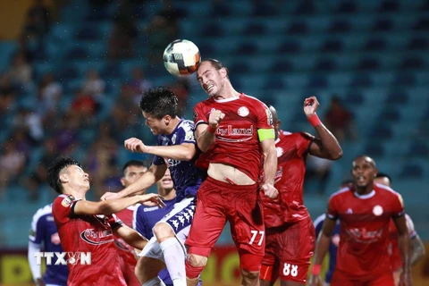 Một pha tranh chấp bóng bổng của cầu thủ hai đội Hà Nội FC (áo tím) gặp đội Thành phố Hồ Chí Minh (áo đỏ) trong trận đấu ở vòng 7 Giải bóng đá vô địch quốc gia Wake-up 247- V.League 2019. (Ảnh: Trọng Đạt/TTXVN)