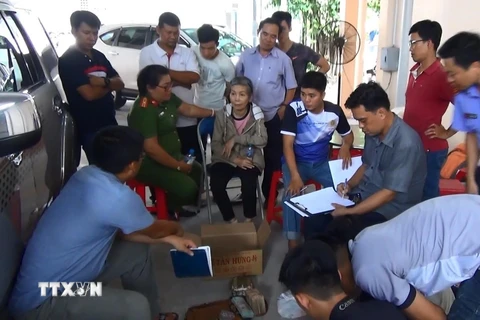 Lực lượng chức năng tiến hành điều tra, khám xét vụ án. (Ảnh: Nguyễn Văn Việt/TTXVN)