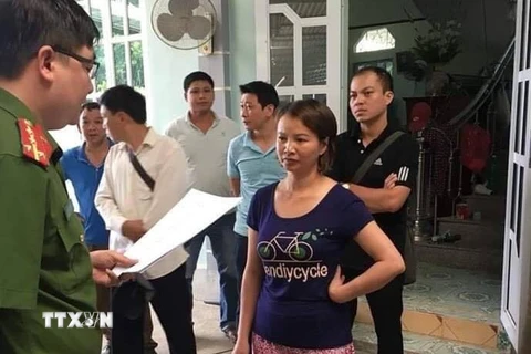Đối tượng Trần Thị Hiền nghe công bố Quyết định khởi tố và Lệnh bắt tạm giam của cơ quan điều tra. (Ảnh: Xuân Tiến/TTXVN)