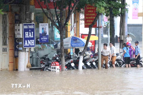 Đường Trường Chinh, thành phố Sơn La bị ngập úng, gây ách tắc giao thông và nước tràn vào nhà dân, cửa hàng bên đường. (Ảnh: Nguyễn Cường/TTXVN)