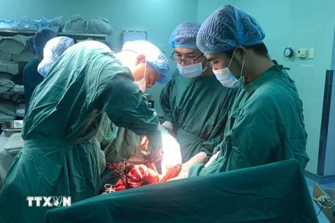 Êkíp bác sỹ đang phẫu thuật cấp cứu cho sản phụ Phạm Thị H. (Ảnh: Lê Xuân/TTXVN)