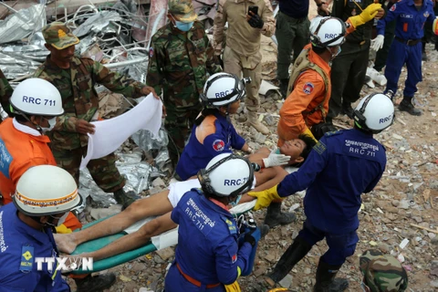 Lực lượng cứu hộ chuyển một nạn nhân sống sót trong vụ sập tòa nhà 7 tầng ở Sihanoukville, tỉnh Preah Sihanouk, Campuchia ngày 24/6. (Nguồn: THX/TTXVN)