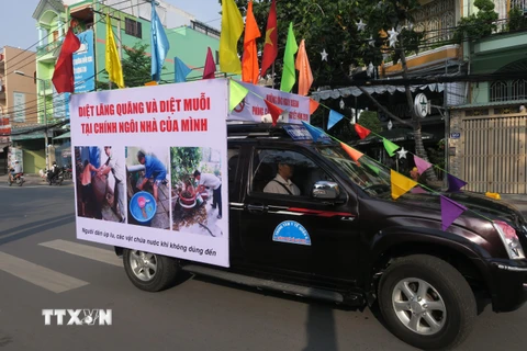 Xe cổ động diễu hành trên đường phố với những thông điệp kêu gọi diệt lăng quăng, phòng chống bệnh sốt xuất huyết. (Ảnh: Đinh Hằng/TTXVN)