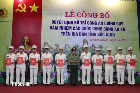 Lãnh đạo Công an tỉnh Bắc Ninh trao quyết định cho các công an chính quy về đảm nhiệm các chức danh trưởng, phó phụ trách công an xã, phường, thị trấn. (Ảnh: Thái Hùng/TTXVN)