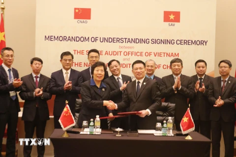 Tổng Kiểm toán nhà nước Việt Nam Hồ Đức Phớc (bên phải) và Tổng Kiểm toán nhà nước Trung Quốc, bà Hồ Trạch Quân ký Bản ghi nhớ hợp tác. (Ảnh: Anh Tuấn/TTXVN)