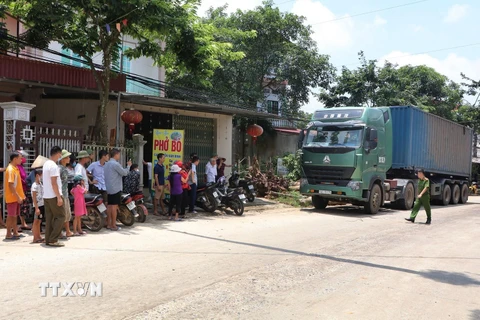 Người dân khu 1 và khu 2 xã Trạm Thản ra chặn đường không cho xe chở rác lưu thông. (Ảnh: Trung Kiên/TTXVN)