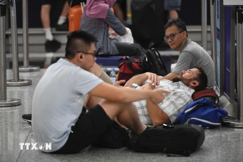 Hành khách chờ đợi tại sân bay quốc tế Hong Kong, Trung Quốc, ngày 12/8. (Nguồn: THX/TTXVN)