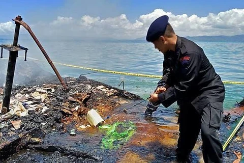 Cảnh sát trên con tàu chở khách bị cháy, chìm dưới nước. (Nguồn: AFP)
