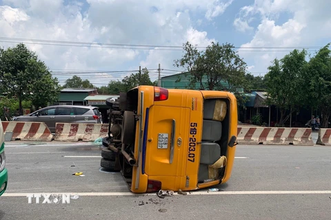 Hiện trường chiếc xe ôtô khách lật ngửa ra đường. (Ảnh: Nguyễn Văn Việt/TTXVN)