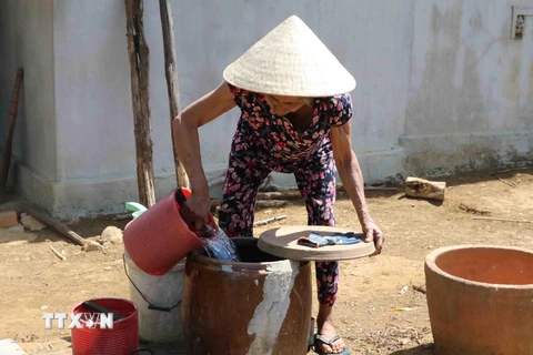Do giếng đào của gia đình đã khô cạn, bà Dương Thị Hồng, 70 tuổi, thôn Suối Phèn, xã Sơn Long, huyện Sơn Hòa hàng ngày vẫn phải đi xin từng gàu nước sinh hoạt về dùng. (Ảnh: Phạm Cường/TTXVN)
