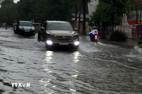 Đường Phong Đình Cảng, thành phố Vinh (Nghệ An) ngập nước khiến phương tiện giao thông đi lại khó khăn. (Ảnh: Tá Chuyên/TTXVN)