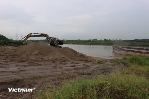 Bãi tập kết vật liệu không phép của Công ty Cổ phần Phúc Long (Long Biên). (Ảnh: Mạnh Khánh/Vietnam+)