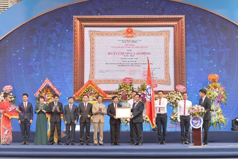 Phó Thủ tướng Vương Đình Huệ trao Huân chương Lao động hạng Nhất (lần thứ 2) cho trường Đại học Vinh. (Ảnh: Bích Huệ/TTXVN)