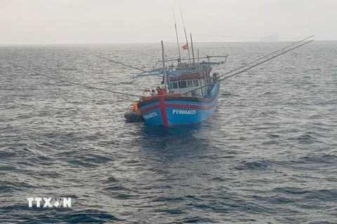 Canô của tàu SAR 413 tiếp cận tàu cá PY 90046 TS chuyển ngư dân Đặng Công Minh về tàu SAR 413 cấp cứu. (Ảnh: Huỳnh Ngọc Sơn/TTXVN)