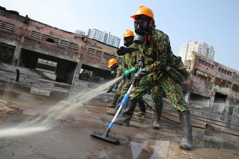 Lực lượng Binh chủng Hoá học phun hóa chất tẩy độc mặt nền nhà xưởng của Công ty Rạng Đông, ngày 5/10. (Ảnh: Dương Giang/TTXVN)